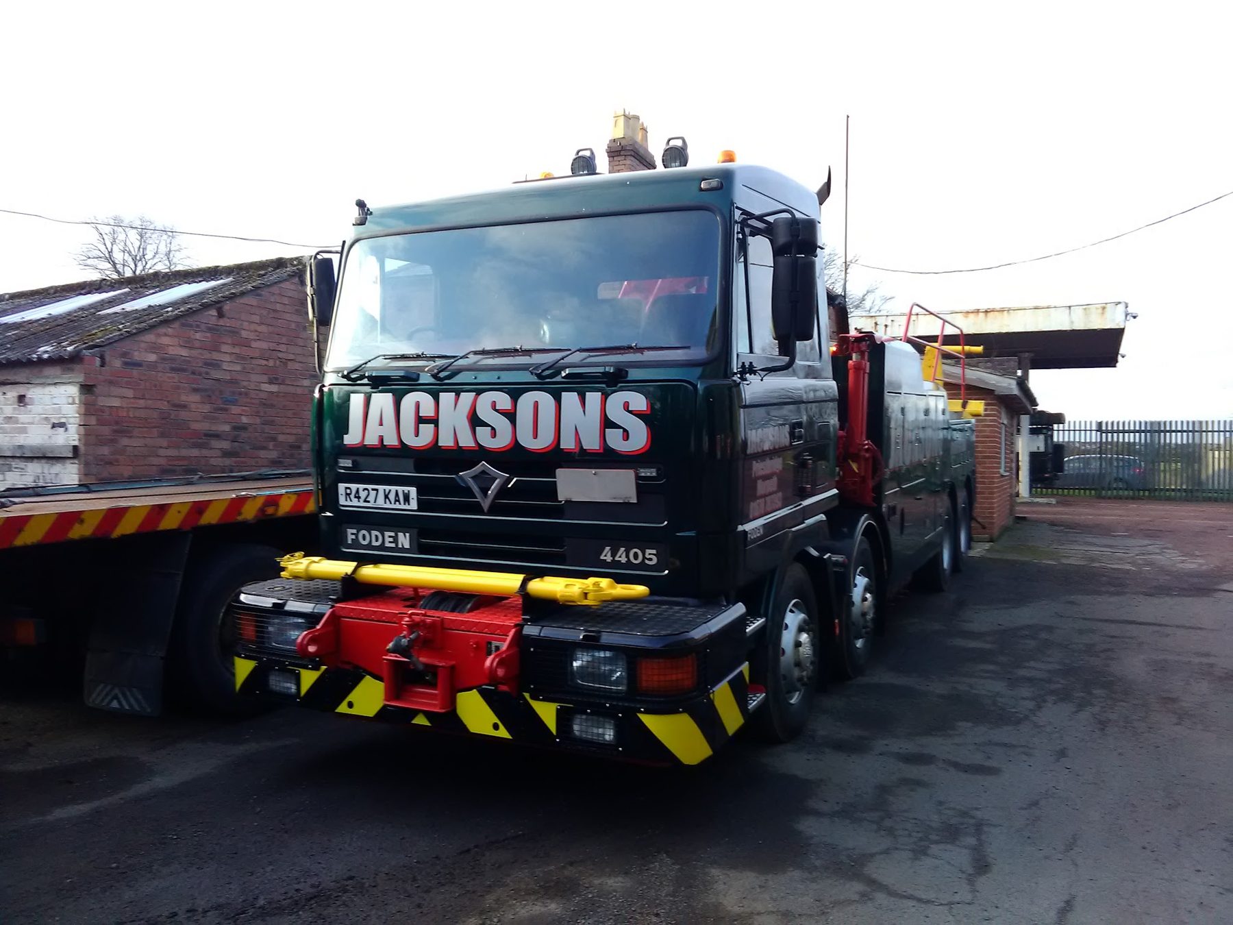 Green JACKSONS Foden eight-wheel recovery truck with a red and yellow chevron bumper